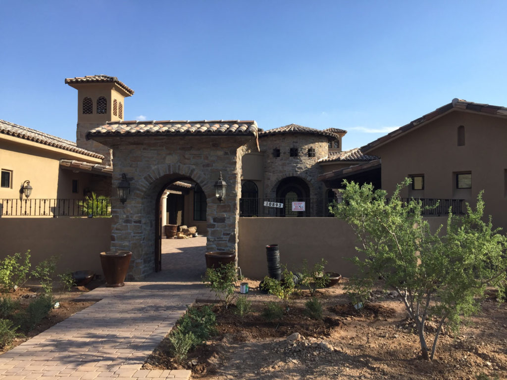 Exterior of classic tuscan custom style home build showing entryway of home with large door